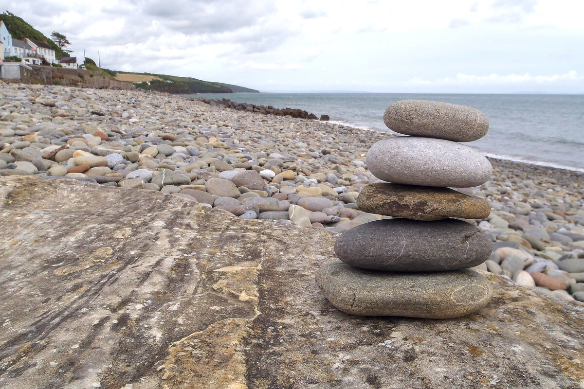 Flat pebbles stacked on the beach at Amroth